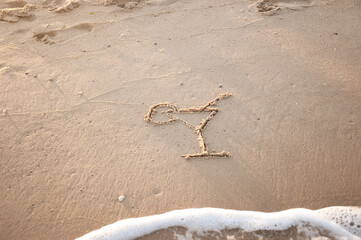 Summer cocktail is drawn on the sea sand. summer sea background