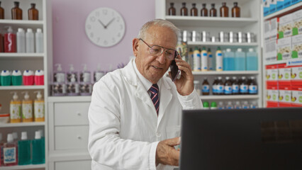 Elderly man in a pharmacy talking on the phone while working on a computer, surrounded by shelves of medicines and bottles, conveying a professional and attentive atmosphere.