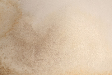 Gold  Ink watercolor grain pour blot on beige empty paper texture background.