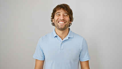 Smiling young caucasian man with beard wearing a blue polo shirt against a white background.