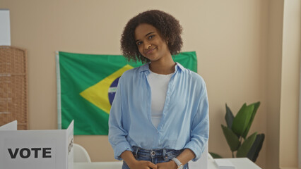 A beautiful young african american woman with curly hair is smiling indoors in a brazilian...