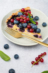 A piece of shortbread pie with blueberries and mint. Seasonal summer baking.