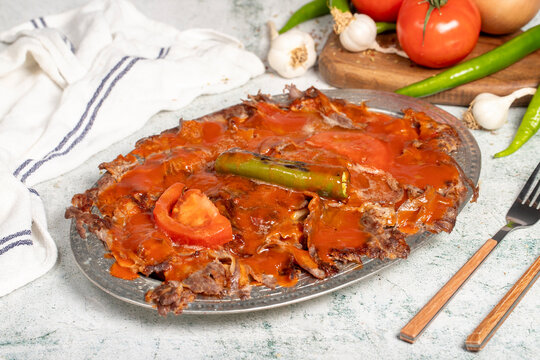 Iskender kebab. Traditional Turkish cuisine taste. Cooked iskender kebab with sauce and butter on a gray background. Close up