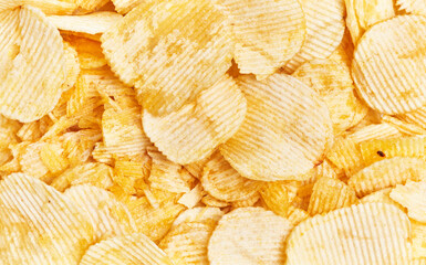 Close-up of crispy golden potato chips filling the frame, perfect for background or texture uses.