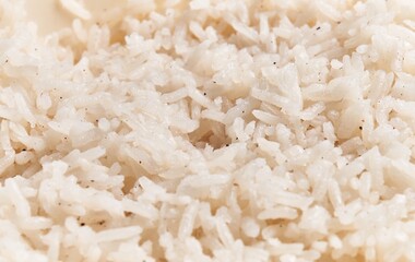 Close-up view of steamed white rice, showcasing its texture and individual grains in a culinary context.