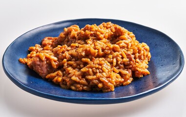 Delicious risotto with sausage served on a blue plate, perfect for italian cuisine and gourmet food concepts.