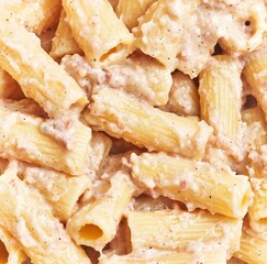 Close-up of creamy pasta alfredo with penne and parmesan, perfect for italian cuisine and recipes visuals.
