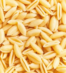 A close-up, textured portrayal of uncooked italian gnocchetti pasta scattered randomly, without any people.