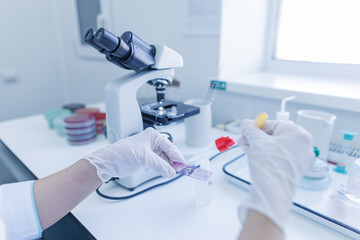 female laboratory assistant conducts research, chemical analysis, analysis of bacteria