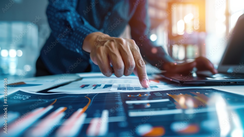 Poster a man is pointing at a graph on a table. the graph shows a downward trend in sales over the past few