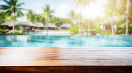 Fototapeta premium Empty wooden tabletop perfect for displaying product over blurred background of tropical resort pool