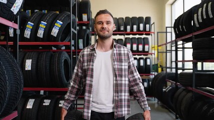 Customer walking in a tire store with two new tires for car