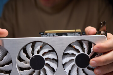 A technician is skillfully repairing a computer GPU fan with precision tools in a workshop