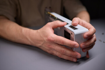 A technician is skillfully repairing a computer GPU fan with precision tools in a workshop