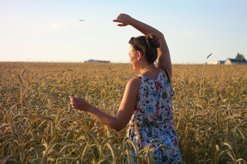 Girl in a wheat field with wucher, summer atmosphere lifestyle.
