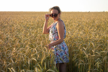 Girl in a wheat field with wucher, summer atmosphere lifestyle.