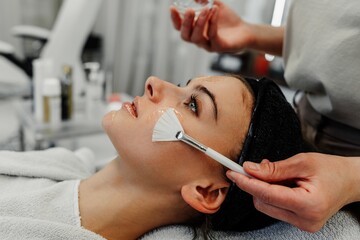 Professional facial skin care. A master massages a woman's face in a beauty salon.