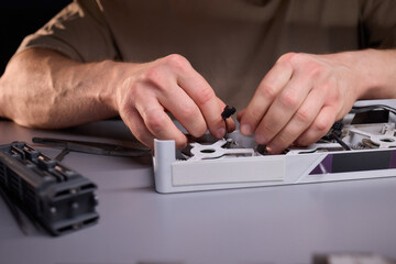 A technician is skillfully repairing a computer GPU fan with precision tools in a workshop