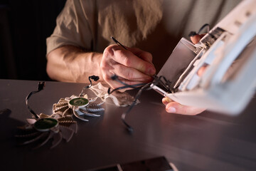 A technician is skillfully repairing a computer GPU fan with precision tools in a workshop