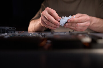 A technician is skillfully repairing a computer GPU fan with precision tools in a workshop