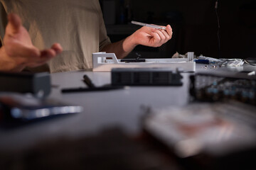 A technician is skillfully repairing a computer GPU fan with precision tools in a workshop