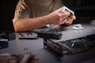 A technician is skillfully repairing a computer GPU fan with precision tools in a workshop