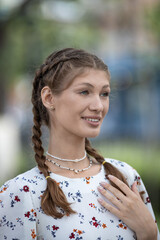 Attractive young caucasian woman is enjoying warm sunny weather walking outside. Brown-haired. Relaxation concept