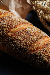 Fresh delicious wheat bread sprinkled with sesame seeds. Homemade baking. Craft bread