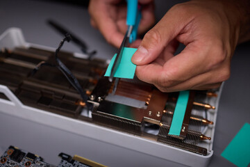 Technician assembling a GPU, focusing on installing computer hardware components