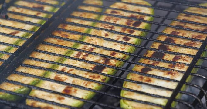 Vegetable marrow are grilled over an open fire. Zucchini was cut lengthwise broils on barbecue