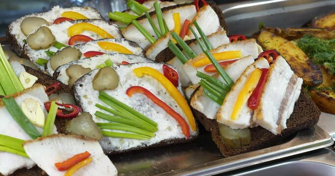 Open sandwiches with white pork lard, onions, peppers, garlic and pickled cucumbers