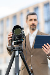 modern professional photographer. in a jacket photographs architecture. the person is blurred / out of focus.