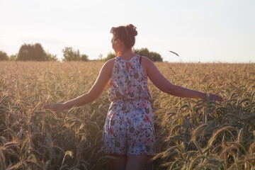 Girl in a wheat field with wucher, summer atmosphere lifestyle.