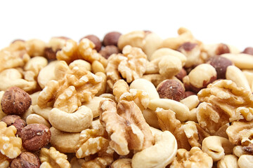 Close-up image of a mixed nuts assortment featuring walnuts, cashews, hazelnuts, and other varieties. The natural colors and textures highlight their freshness and nutritional value