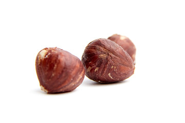 Close-up of three hazelnuts isolated on a white background. Ideal for food and health-related visuals