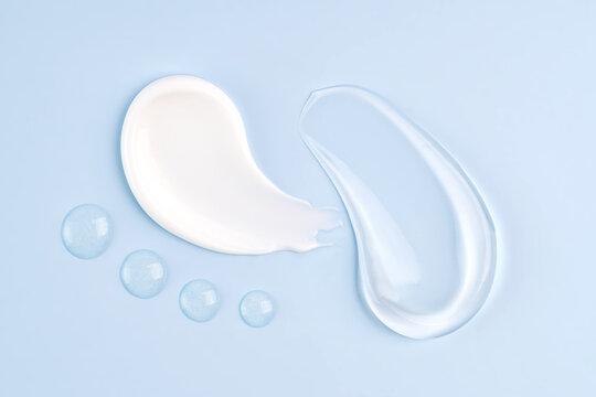 White and translucent cosmetic beauty smears on blue background