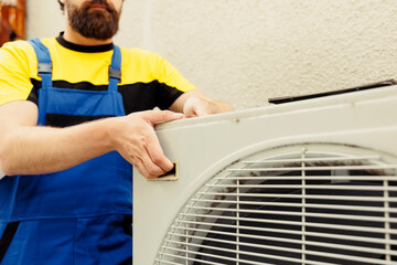 Knowleadgeable technician getting new external hvac system ready after replacing damaged unit. Efficient mechanic employed to install air conditioner and make sure it operates at maximum performance