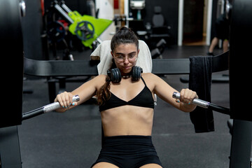 Caucasian young woman doing workout in the gym. Fitness, wellness exercise concept