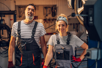 Portrait of colleagues technicians at auto mechanic workshop smiling.