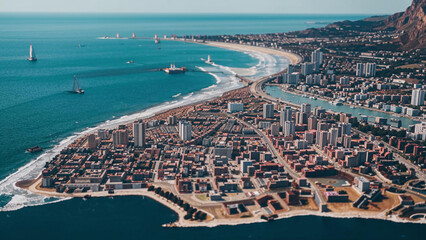 aerial view of a city with a beach and a body of water