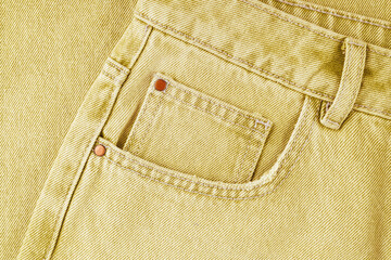 Front pocket, small pocket, details of  yellow jeans pants close up, macro