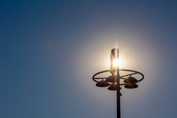 Summer landscape, Silhouette of street lamp post with sun flare, Light pole with sparkle sun and...