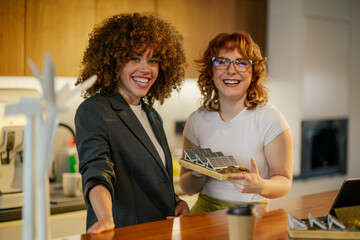 Happy ecology engineers with solar panels at office smiling at camera.