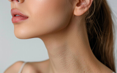 A close-up photograph of a woman's neck, isolated on a white background. The image showcases the soft curves of her neck, the delicate texture of her skin, and the subtle lines of her jawline