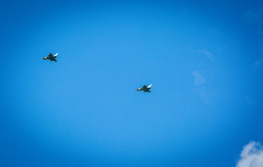 Two RAF typhoons flying, flying in formation back to their respected air fields after taking part in the kings fly past on a beautiful summers day with blue skies and slight cloud