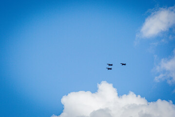 Three Hawk fighter jets flying in formation back to their air base after taking part in the kings birthday fly past, Image shows the trainer aircraft with a blue sky and slight white cloud background