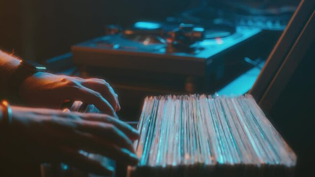 DJ in retro club going through a box of vinyl records, vinyl player in neon light, retro video stylization