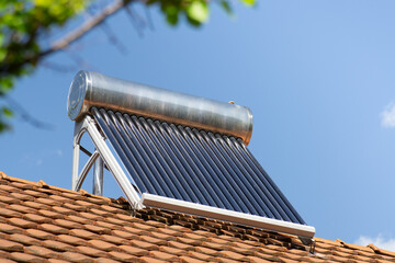 solar water heater on a roof top, solar water heating panel, blue sky in the background