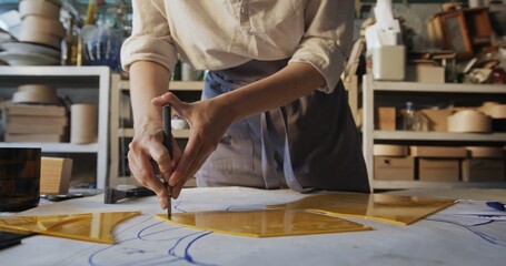 Close-Up of Glass Artist Cutting Yellow Petal for Decorative Mirror