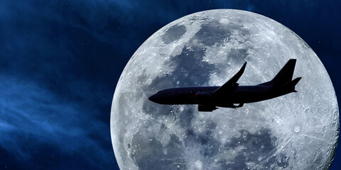 Close-up color photo of a silhouetted passenger plane illuminated by a beautiful full moon against a starry night sky.